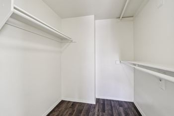 A white room with a wooden floor and a white door.